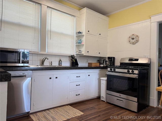 1032 E Mcleod Ave, Sapulpa, OK 74066 - kitchen with appliances with stainless steel finishes, crown molding, dark countertops, white cabinets, and dark wood-style floors