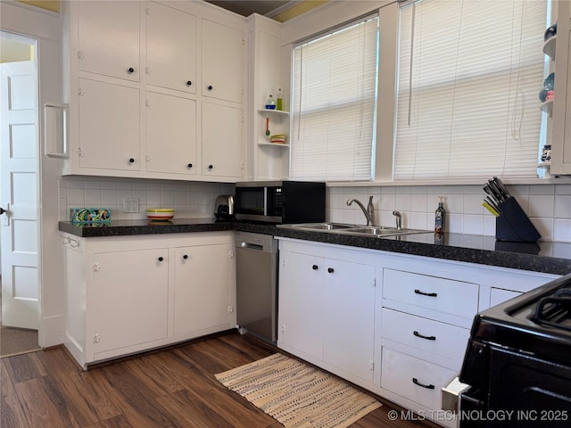 1032 E Mcleod Ave, Sapulpa, OK 74066 - kitchen with stainless steel appliances, dark wood finished floors, tasteful backsplash, and white cabinets