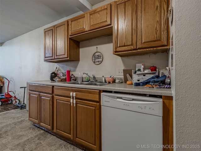 940 N Ross Ave, Dewey, OK 74029 - kitchen with dishwasher, a sink, brown cabinetry, light countertops, and a textured wall