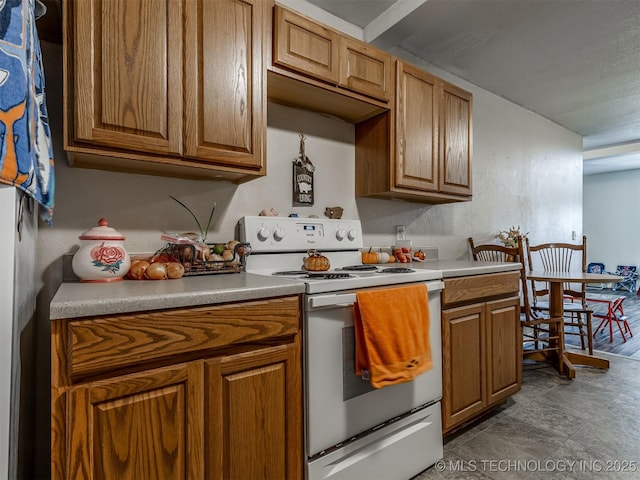 940 N Ross Ave, Dewey, OK 74029 - kitchen with white electric stove, brown cabinetry, and light countertops