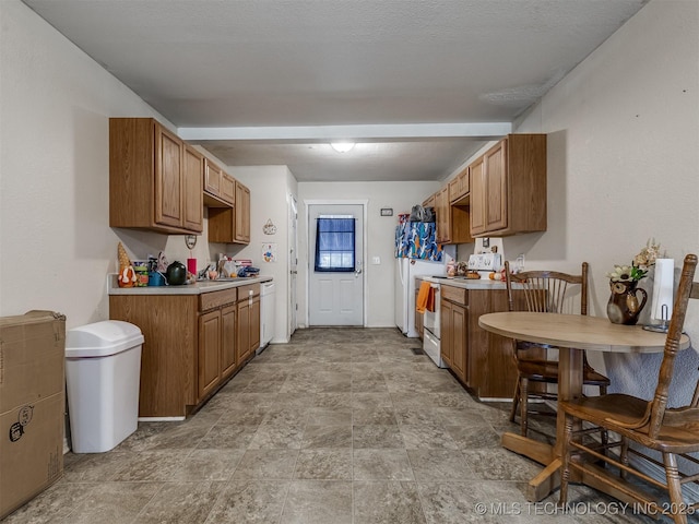 940 N Ross Ave, Dewey, OK 74029 - kitchen featuring white appliances, stone finish flooring, light countertops, and brown cabinets