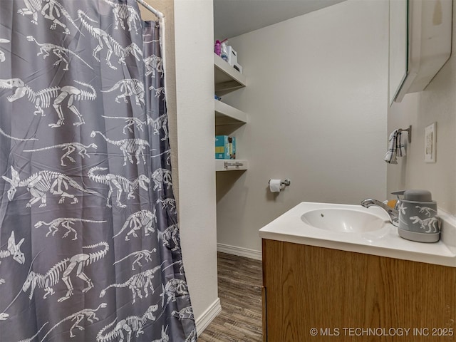 940 N Ross Ave, Dewey, OK 74029 - bathroom featuring wood finished floors, vanity, baseboards, and a shower with curtain