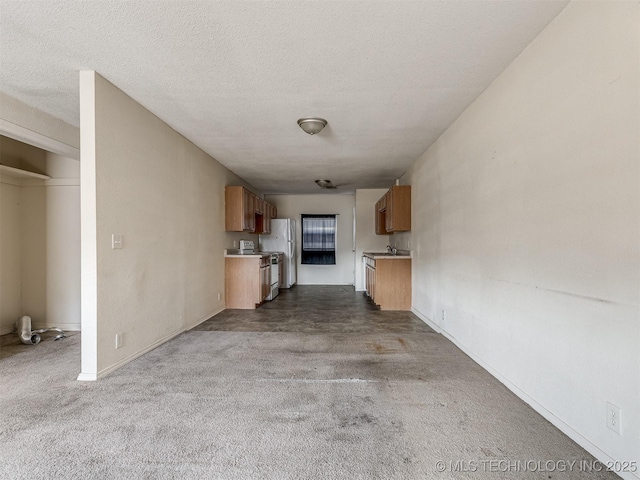 940 N Ross Ave, Dewey, OK 74029 - unfurnished living room featuring dark carpet, a textured ceiling, and baseboards
