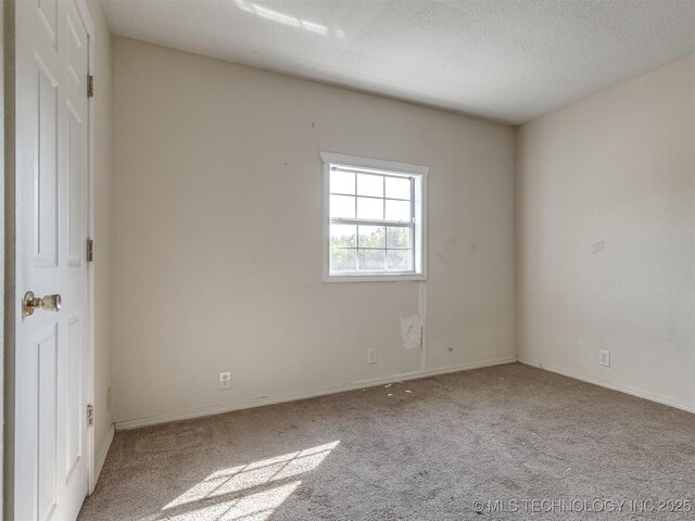 940 N Ross Ave, Dewey, OK 74029 - carpeted spare room with baseboards and a textured ceiling