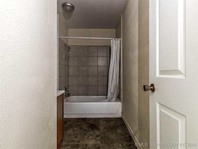 940 N Ross Ave, Dewey, OK 74029 - bathroom with a textured wall, shower / bath combo, vanity, and baseboards