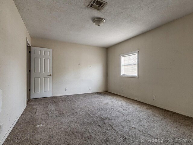 940 N Ross Ave, Dewey, OK 74029 - carpeted empty room featuring a textured ceiling and baseboards