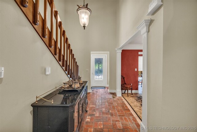 3112 Shore Dr, Grove, OK 74344 - foyer entrance featuring brick flooring, a high ceiling, baseboards, stairway, and decorative columns