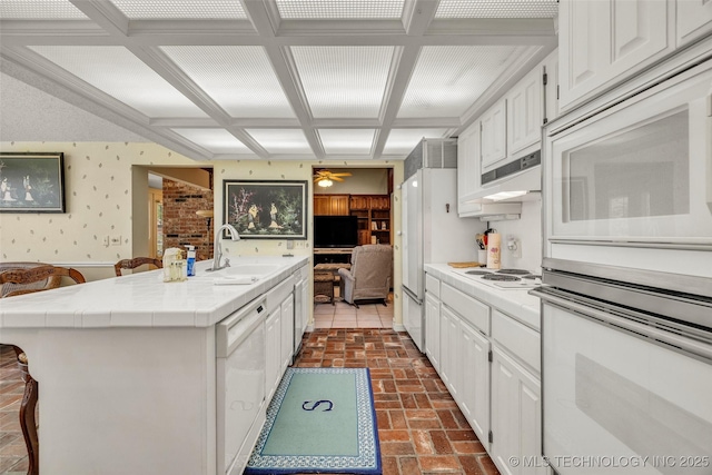 3112 Shore Dr, Grove, OK 74344 - kitchen with white appliances, a sink, white cabinetry, coffered ceiling, and wallpapered walls
