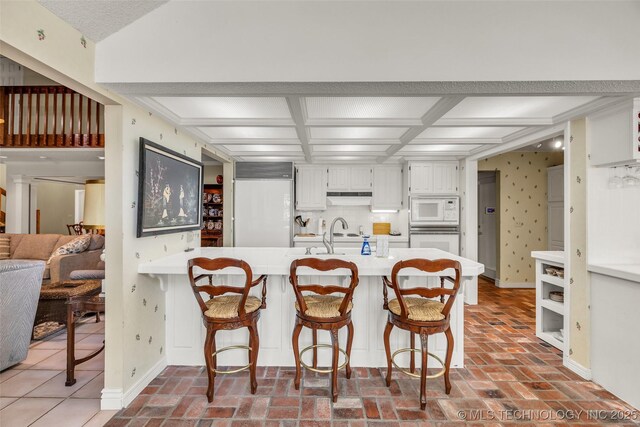 3112 Shore Dr, Grove, OK 74344 - kitchen featuring built in appliances, light countertops, a peninsula, white cabinets, and brick floors