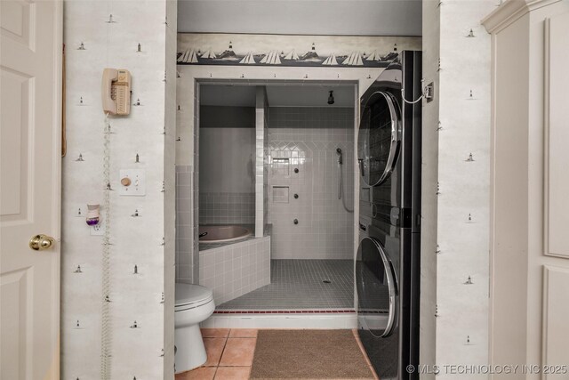 3112 Shore Dr, Grove, OK 74344 - bathroom featuring stacked washer and clothes dryer, tile patterned floors, toilet, and tiled shower