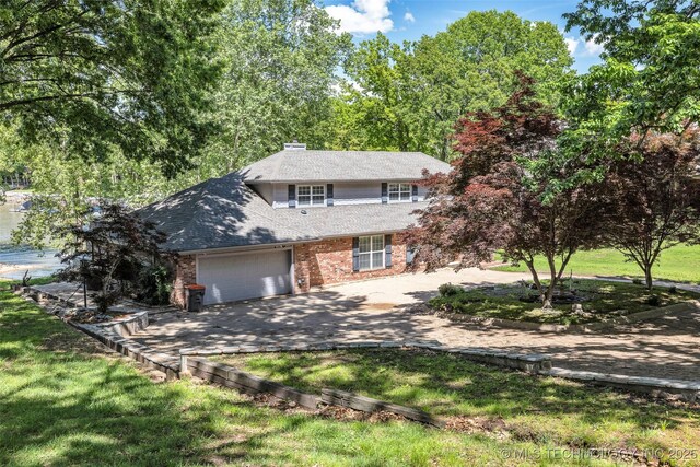 3112 Shore Dr, Grove, OK 74344 - view of front facade with brick siding, a garage, driveway, and a shingled roof