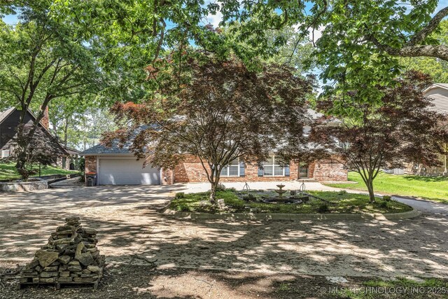 3112 Shore Dr, Grove, OK 74344 - obstructed view of property with brick siding, driveway, and an attached garage