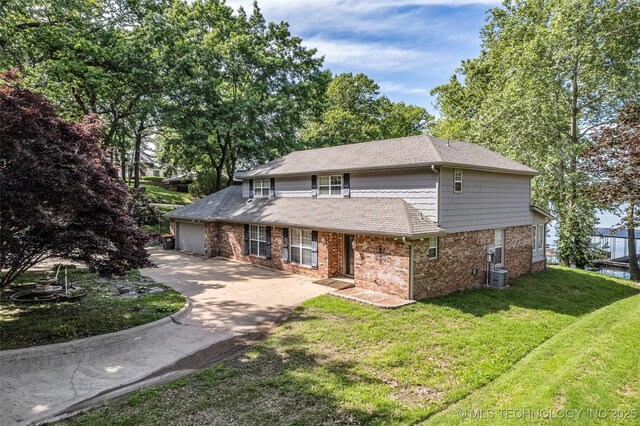 3112 Shore Dr, Grove, OK 74344 - view of front facade featuring central air condition unit, driveway, brick siding, a front lawn, and an attached garage