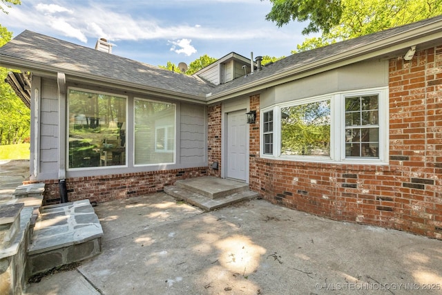 3112 Shore Dr, Grove, OK 74344 - entrance to property with brick siding, a patio area, a chimney, and roof with shingles