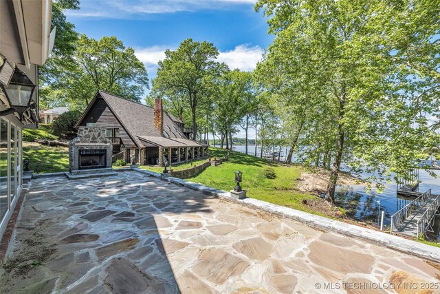 3112 Shore Dr, Grove, OK 74344 - view of patio with an outdoor stone fireplace and a water view
