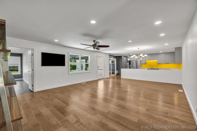 3130 E 47th St, Tulsa, OK 74105 - unfurnished living room with recessed lighting, a chandelier, a ceiling fan, wood finished floors, and baseboards