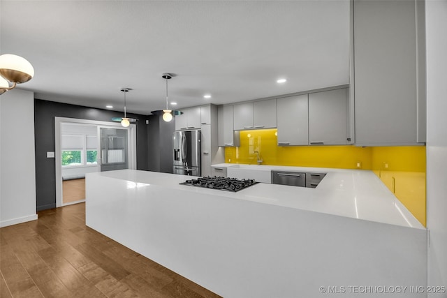 3130 E 47th St, Tulsa, OK 74105 - kitchen featuring stainless steel appliances, a peninsula, recessed lighting, light countertops, and dark wood finished floors