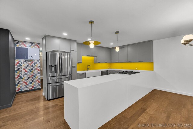 3130 E 47th St, Tulsa, OK 74105 - kitchen featuring stainless steel refrigerator with ice dispenser, gray cabinets, a peninsula, wood finished floors, and gas stovetop