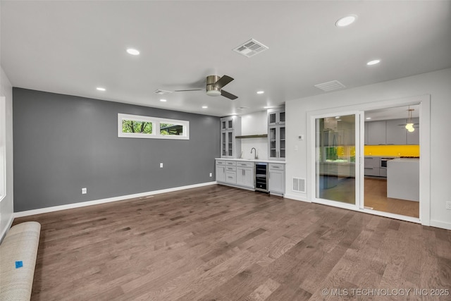 3130 E 47th St, Tulsa, OK 74105 - unfurnished living room featuring a ceiling fan, wine cooler, recessed lighting, bar, and baseboards