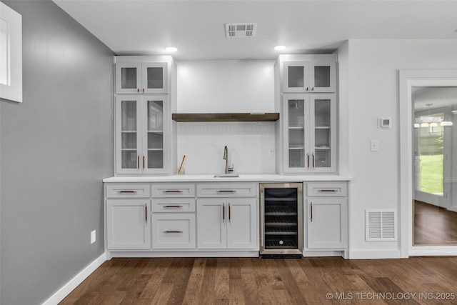 3130 E 47th St, Tulsa, OK 74105 - indoor wet bar featuring beverage cooler, dark wood finished floors, baseboards, backsplash, and recessed lighting