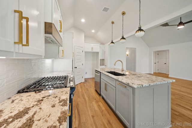 kitchen featuring a sink, stainless steel appliances, vaulted ceiling, decorative backsplash, and gray cabinets