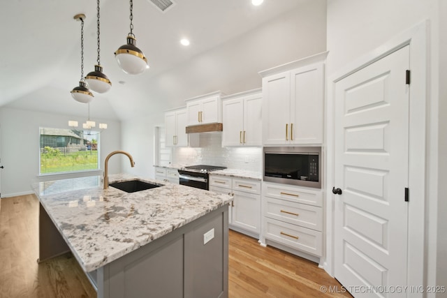 23191 E 106th St S, Broken Arrow, OK 74014 - kitchen featuring a sink, built in microwave, gas stove, tasteful backsplash, and an island with sink