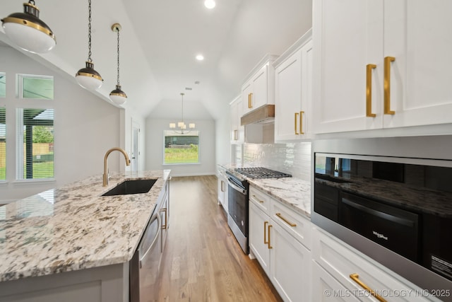 kitchen featuring a sink, appliances with stainless steel finishes, backsplash, light wood finished floors, and recessed lighting