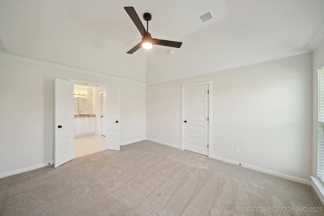 unfurnished bedroom featuring light colored carpet, ensuite bathroom, baseboards, a ceiling fan, and ornamental molding