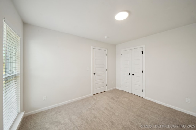 spare room featuring carpet and baseboards
