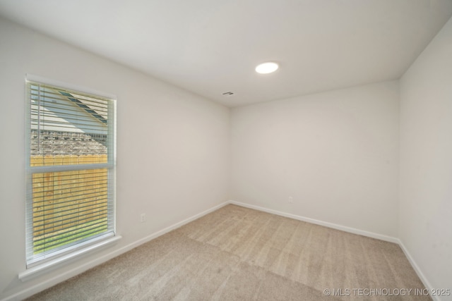 unfurnished room featuring carpet floors and baseboards