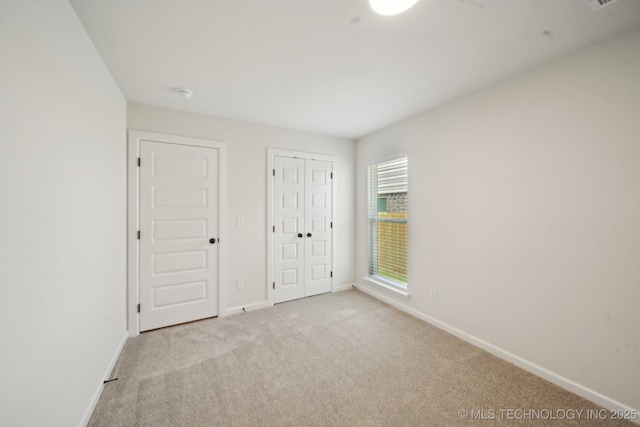 unfurnished bedroom featuring carpet and baseboards