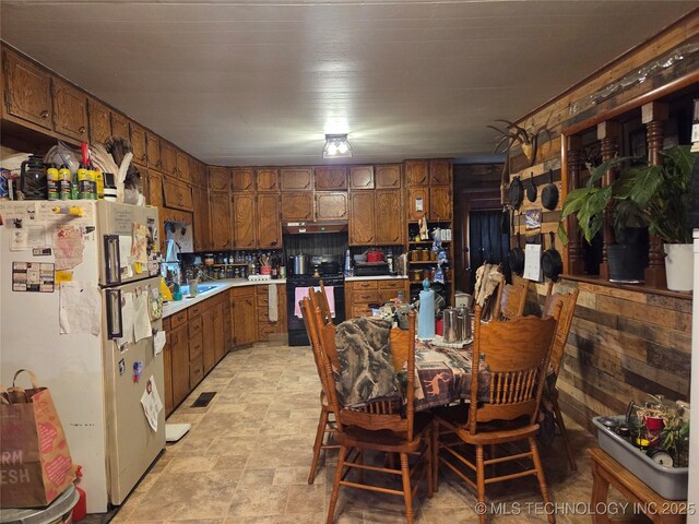 35530 W 261st St, Bristow, OK 74010 - kitchen featuring freestanding refrigerator, black range with gas cooktop, light countertops, and brown cabinetry