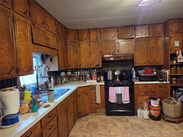 35530 W 261st St, Bristow, OK 74010 - kitchen featuring black gas range, under cabinet range hood, light countertops, and brown cabinetry