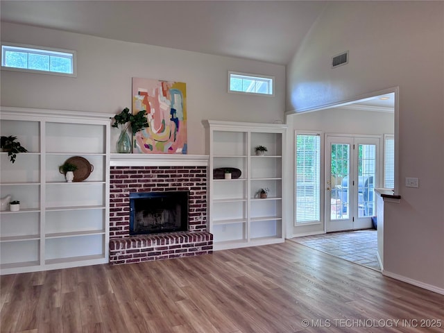 unfurnished living room featuring wood finished floors, a fireplace, high vaulted ceiling, and baseboards
