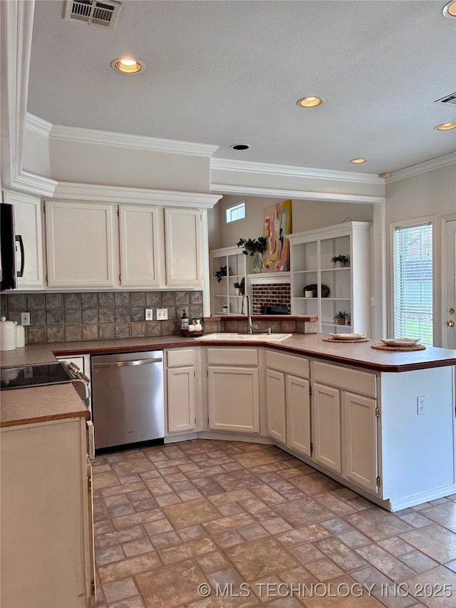 kitchen with stainless steel dishwasher, a sink, a peninsula, tasteful backsplash, and white cabinets