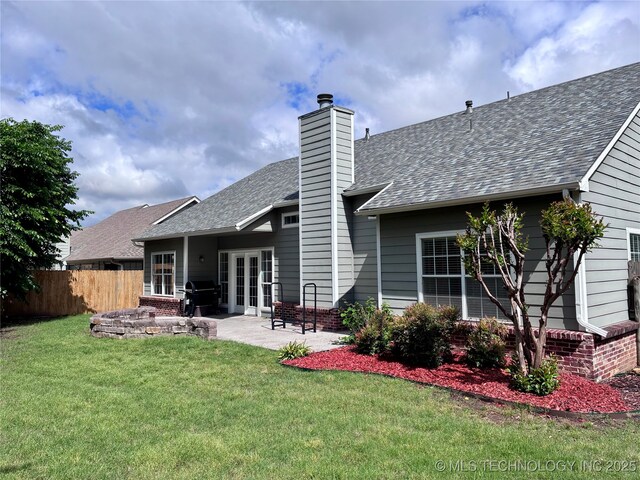 back of property featuring french doors, a shingled roof, a patio, a chimney, and brick siding