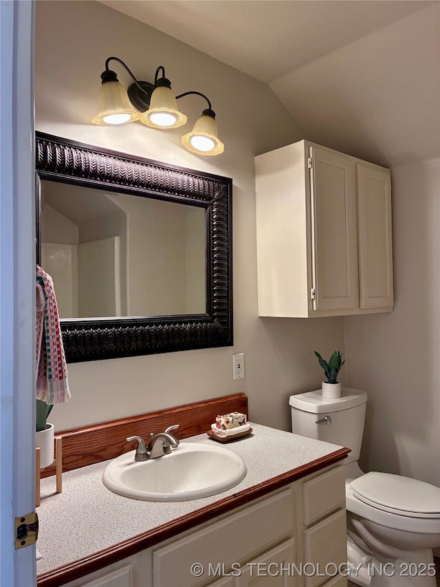 half bath with toilet, vanity, and vaulted ceiling