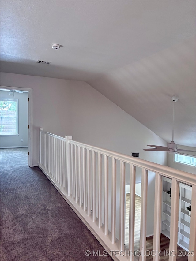 corridor with carpet and vaulted ceiling