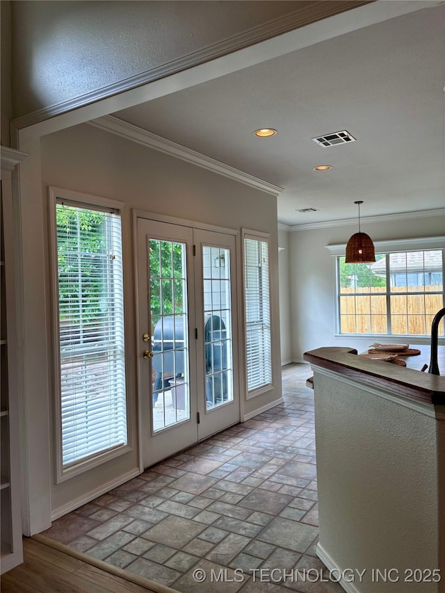 entryway with crown molding, recessed lighting, and healthy amount of natural light
