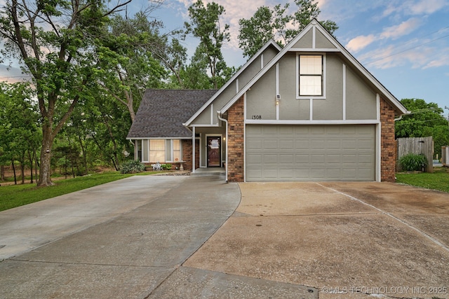 view of front of house featuring driveway, stucco siding, a shingled roof, and an attached garage