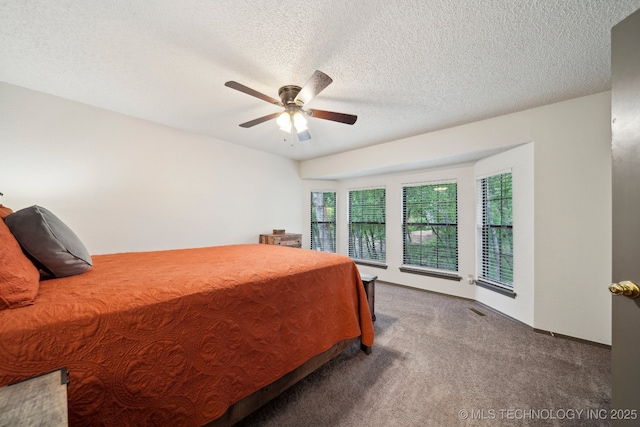 bedroom with carpet flooring, a ceiling fan, and a textured ceiling