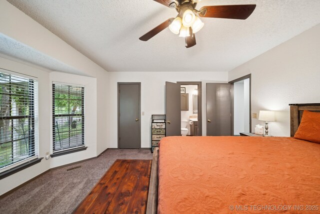 carpeted bedroom with a textured ceiling, ceiling fan, and ensuite bath
