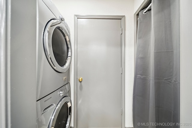 washroom featuring stacked washing machine and dryer