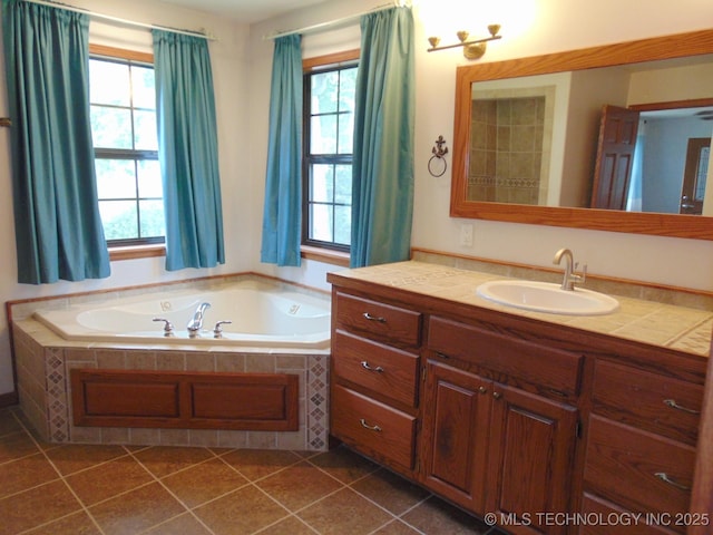 full bathroom with healthy amount of natural light, a bath, vanity, and tile patterned flooring