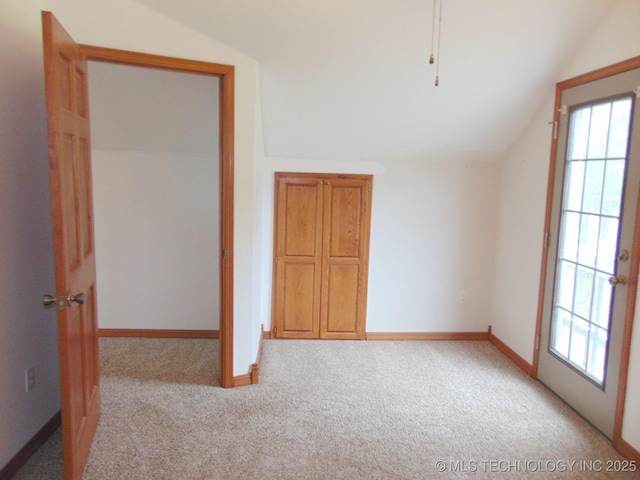 additional living space featuring lofted ceiling, carpet floors, plenty of natural light, and baseboards