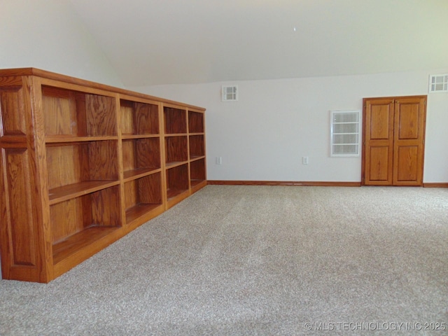 unfurnished room with vaulted ceiling, carpet floors, and baseboards