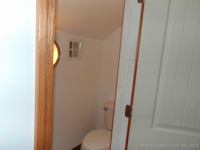 bathroom with toilet and lofted ceiling