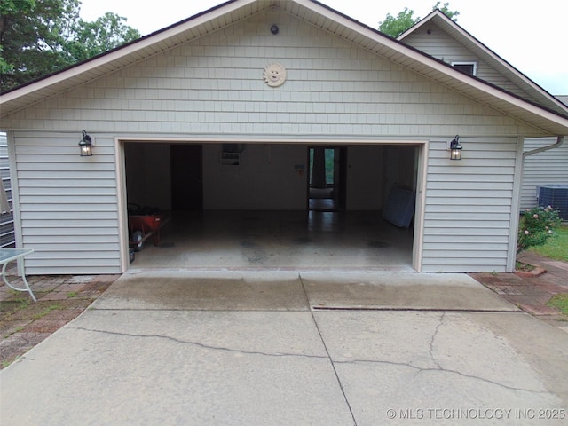 garage featuring driveway and central AC unit