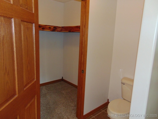 bathroom with toilet and baseboards