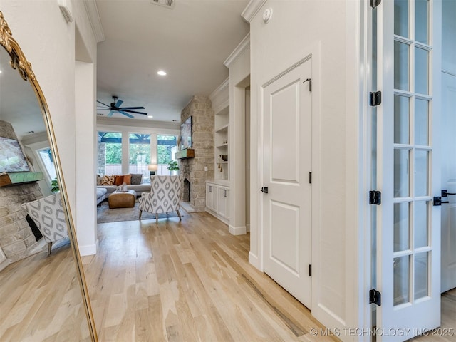 hall with light wood-type flooring, recessed lighting, and built in features